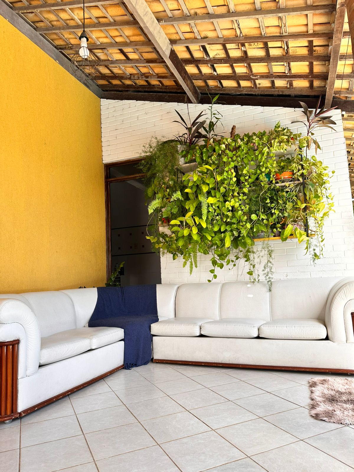 Área de descanso com sofá e plantas